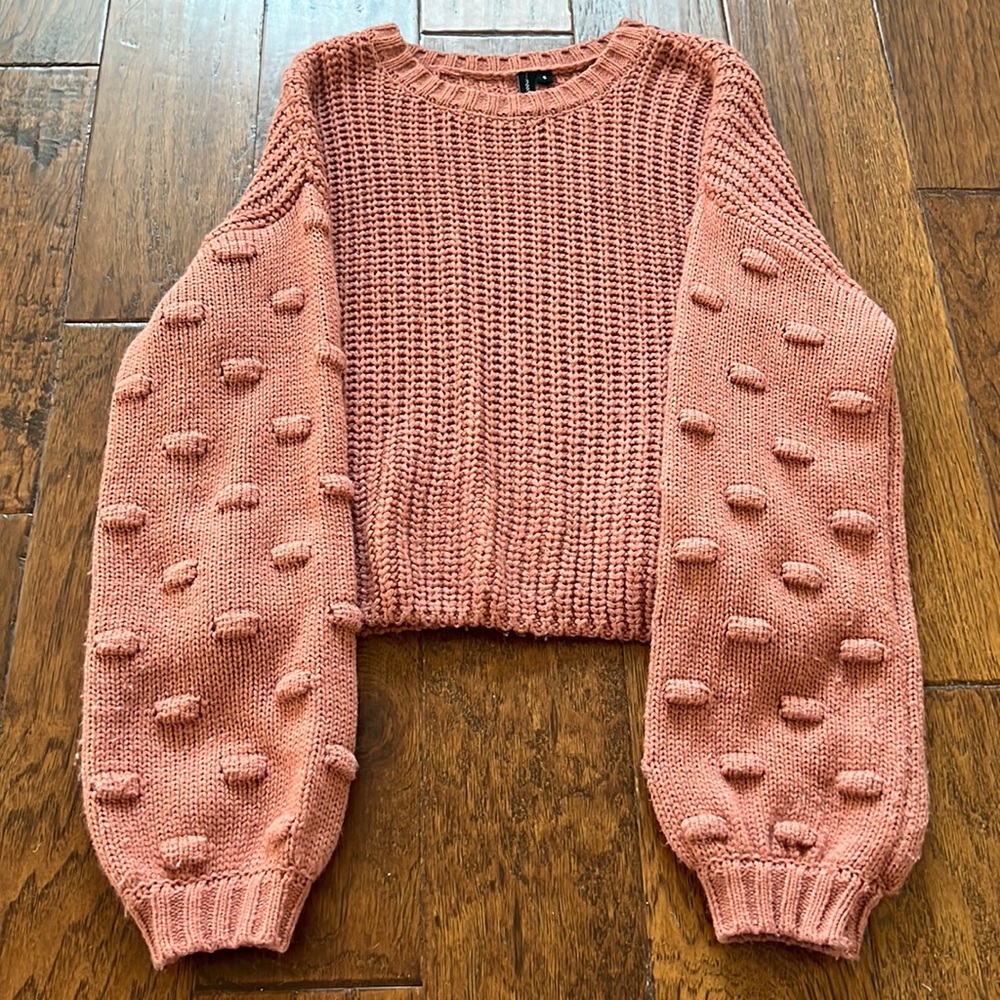 Mauve sweater with detailed sleeve.